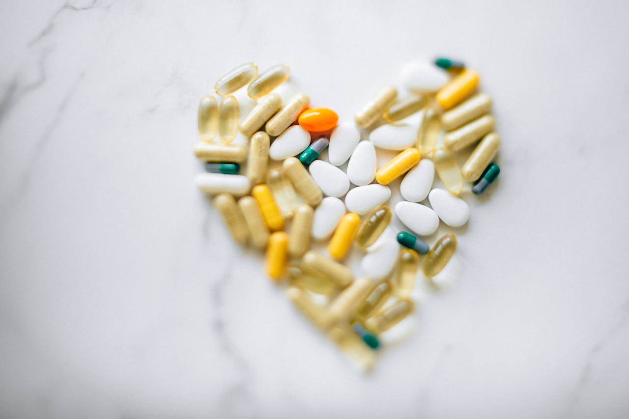 Services-03 Colorful pills arranged in heart shape on a marble surface, symbolizing health and wellness.