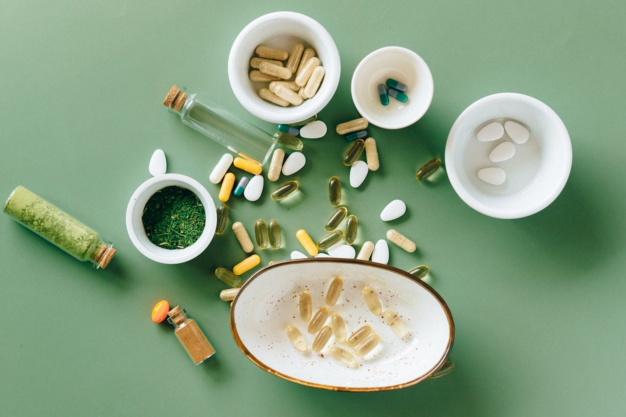 Services-01 Top view of various herbal and pharmaceutical supplements in ceramic bowls on a green background.