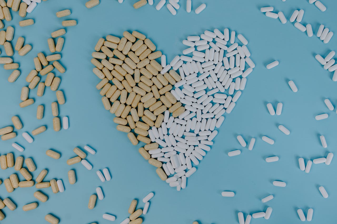 Services-02 Heart-shaped design made of pills and tablets on a blue background, symbolizing health and medicine.