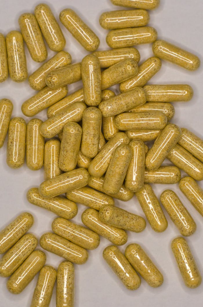 creative A top view of numerous herbal capsules on a gray surface, representing natural healthcare remedies.